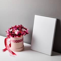 Blank canvas mockup with dried flowers on gray wall