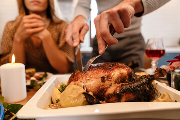 Multiracial happy friends eating turkey during thanksgiving dinner