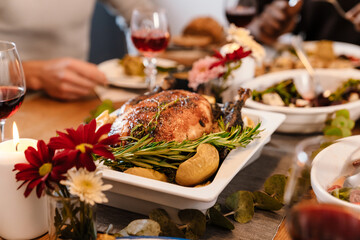 Multiracial happy friends eating turkey during thanksgiving dinner