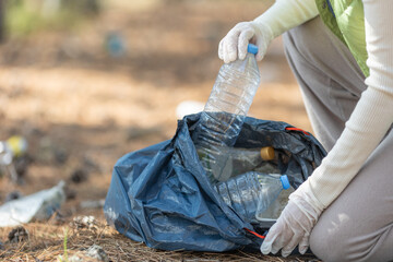A woman removes rubbish in nature. High quality photo - 462658956