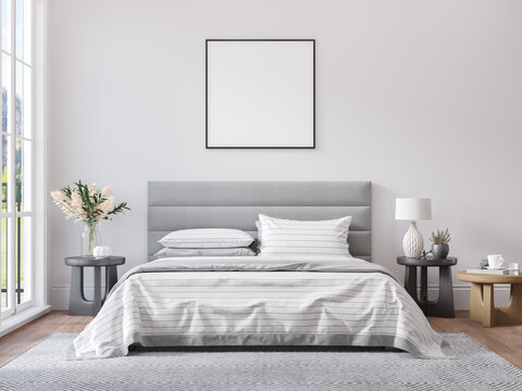 Empty square frame for print or poster mockup on white wall in modern neutral gray bedroom interior with wood floor, rug with geometric pattern, bedside tables, lamps, decor and plants.