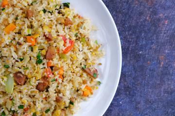 fried rice on the white plate on a black background
