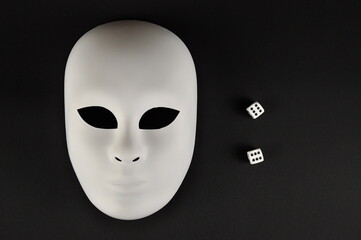 White theatrical mask and playing dice