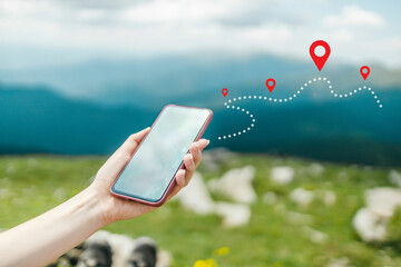 Woman hand using smart phone on top of mountain with navigator location point. Amazing Carpathians...