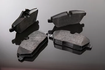 Fotobehang image photograph of brake pads on a black and gray background © Ivan Traimak