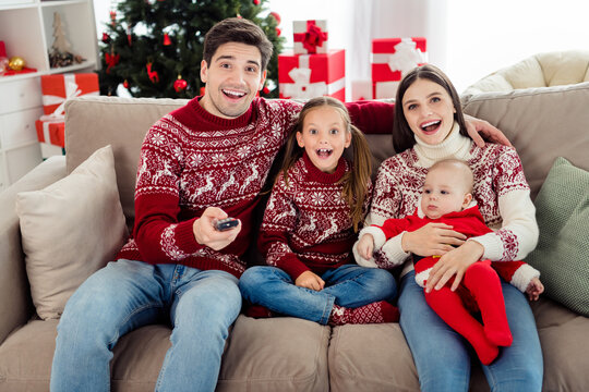 Photo of amazed wife husband children family sit sofa watch tv switch channel xmas spirit indoors inside house home