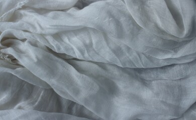 Delicate grey fabric with beautiful pleats. Silk, satin are folded freely. It can serve as a background for the inscription.