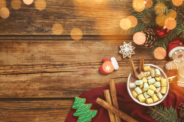 Delicious hot chocolate with marshmallows near cookies and Christmas decor on wooden table, flat lay. Space for text