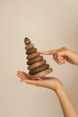 Female hands hold a wooden pyramid on a white background