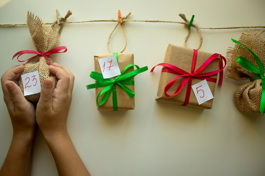 Focus On The Hands Of A Child Holding A Gift For The Advent Calendar, Number 23, DIY Crafts, Seasonal Activities For Children, Family Winter Holidays