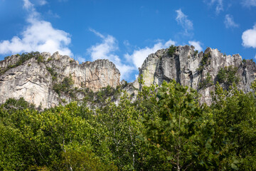 Steep rugged Seneca Rocks Cliffs with tree foreground and blue sky in Monangahela National Forest