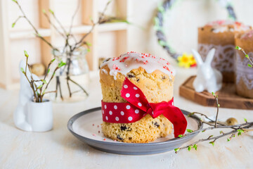 Traditional Easter cupcake, covered with sugar fondant, on a ceramic plate on a light concrete background.