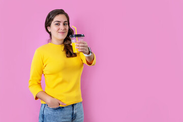 Woman drinking orange fresh juice over pink background.