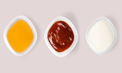 Splashes of tomato ketchup, mayonnaise and mustard on the desk