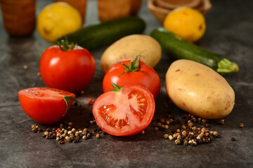 red tomato, potatoes, zucchini and pepper on the gray background - closeup