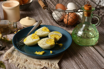hard boiled eggs on blue plate with ingredients around - closeup