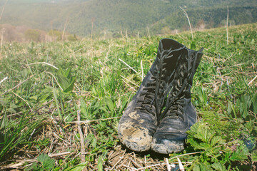 dirty hiking boots on the grass during a halt during a hike