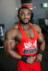 Muscular bodybuilder in gym. Strong male posing in front of the camera.