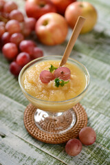 apple and grape mousse in glass cup with fruit around - closeup