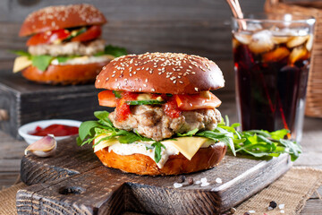 Burgers with cutlet, tomato, arugula, cucumber, onion and cheese. American cuisine. Fast food.