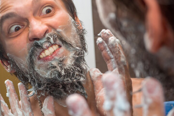 Beard care - a man washes his beard with soap foam