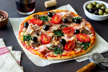 Pizza with bacon, mushrooms, tomatoes, cheese and olives. Italian food.