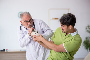 Young male patient visiting old male doctor in expensive medicin