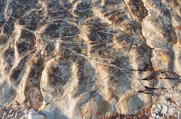 Rock formation on the coast of Dzhanhot (Russia) close-up. Texture, background layers and cracks in sedimentary rock on cliff face. Rock slate in the mountain. Seamless abstract background.