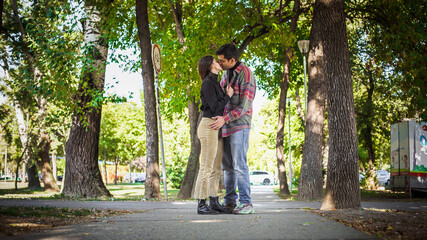 Fototapeta na wymiar Couple in love hugging and kissing in park. French deep kiss.