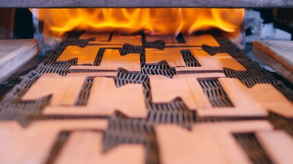 Copper elements laid out on the conveyor are getting burnt