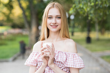 Portrait of an attractive and happy blonde girl with a cup of coffee. Pretty lady