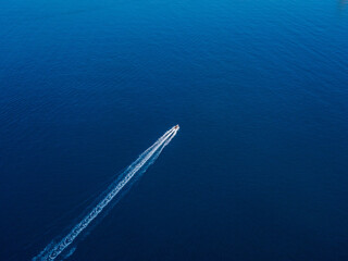 Top view of a motorboat sailing in clear water of the blue sea