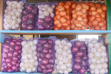 Assorted red, white and yellow onions. Grids of vegetables on the market counter