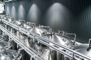 Private microbrewery. Modern beer plant with brewering kettles, tubes and tanks made of stainless steel