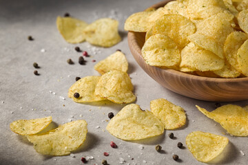Potato chips in wooden bowl on a concrete background