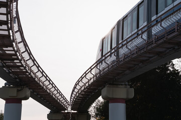 Monorail, rail transport, embranchement. Bottom view. The train turns sideways. The lights of a sun