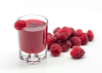 glass with raspberry alcoholic drink and raspberries on white background  
