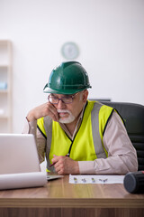 Old male architect working in the office