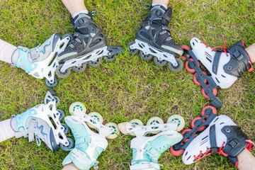 Cropped photo of people with inline skates together in the grass of a park