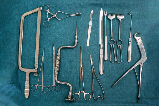 Set of steel surgical tools on blue cloth - real instruments used in mobile medical army tent