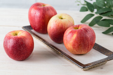 Juicy beautiful ripe red apples of the early winter variety Gala on white wooden table