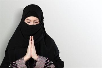 Muslim Girl wearing a surgical mask praying. Covid-19 coronavirus concept.