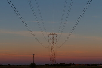 Fototapeta na wymiar High voltage pole at sunset. Electricity grid