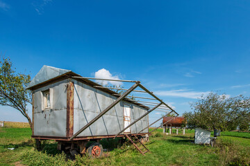 Fototapeta na wymiar vintage mobile prefabricated house installed in a field with water tank