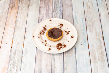 oatmeal and chocolate cookie with cocoa powder on white plate
