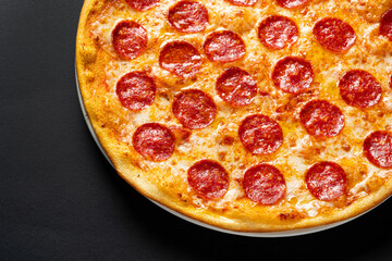 Tasty pepperoni and tomatoes on black  background