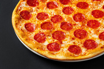 Tasty pepperoni and tomatoes on black  background