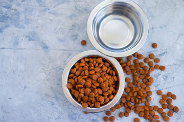 dry animal food in a bowl on a concrete background