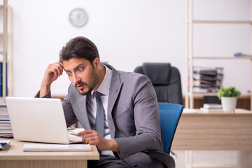 Young male employee working in the office