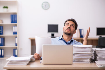 Young male employee and too much work in the office